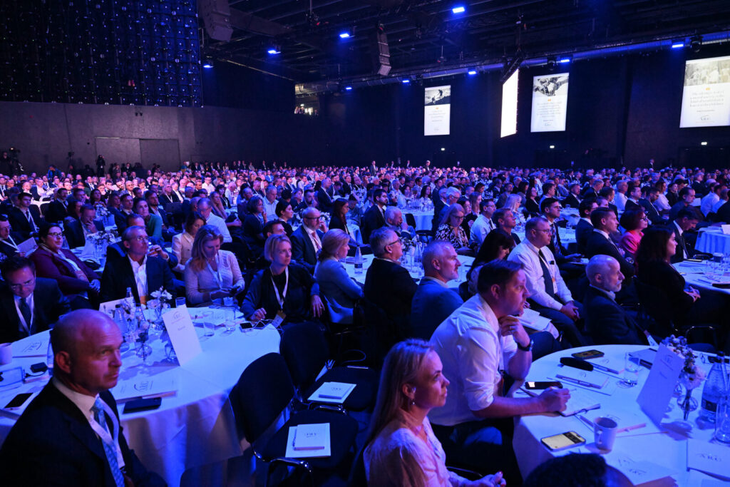 Delegates seated at banquet rounds in a large corporate conference hall