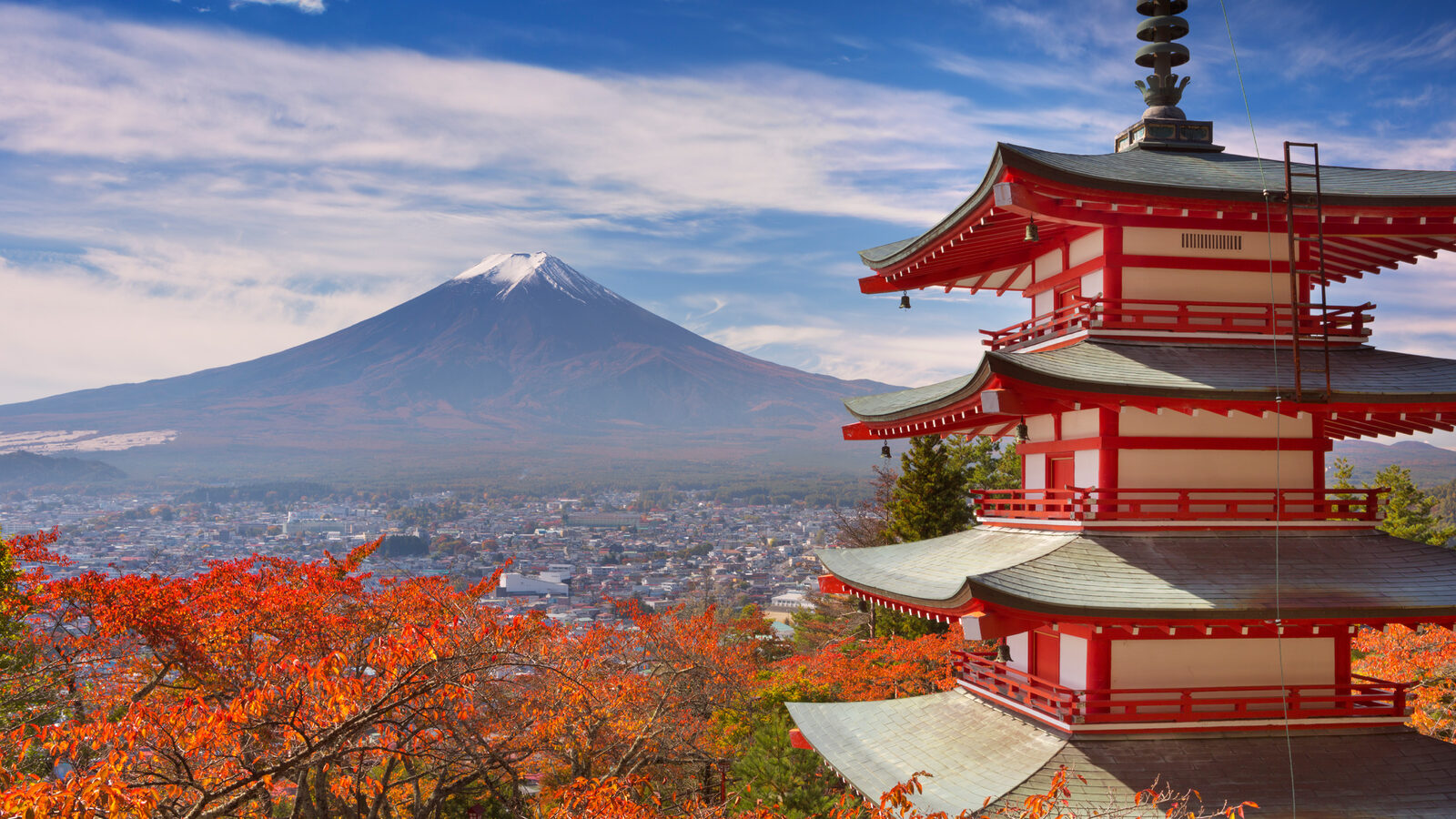 Snow-capped Mount Fuji behind the Chureito Pagoda framed by red autumn leaves