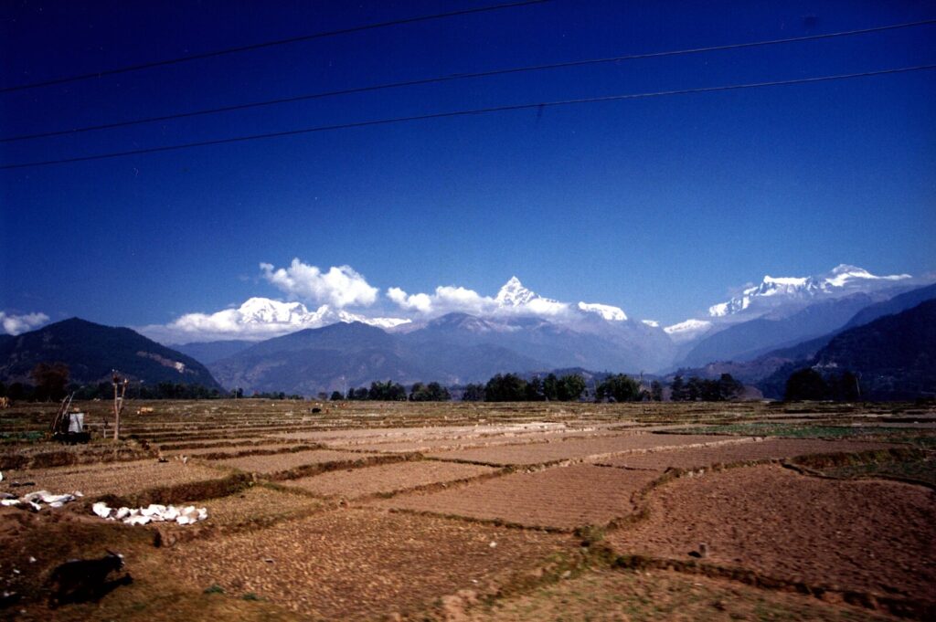 Snow-capped Annapurna and Machapuchare peaks rising above the Pokhara valley under a clear autumn sky in Nepal