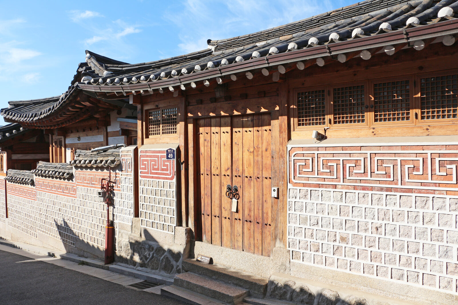 Traditional tiled-roof hanok houses lining a lane in Bukchon Hanok Village, Seoul