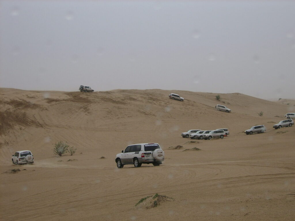 Convoy of 4x4 vehicles dune-bashing in the Dubai desert on a corporate team-building day