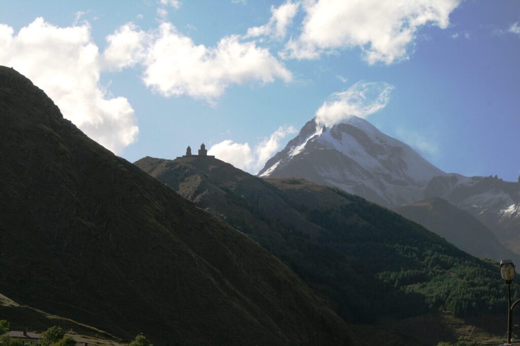 Gergeti Trinity Church on a ridge below the snow-capped peak of Mount Kazbek, Kazbegi, Georgia