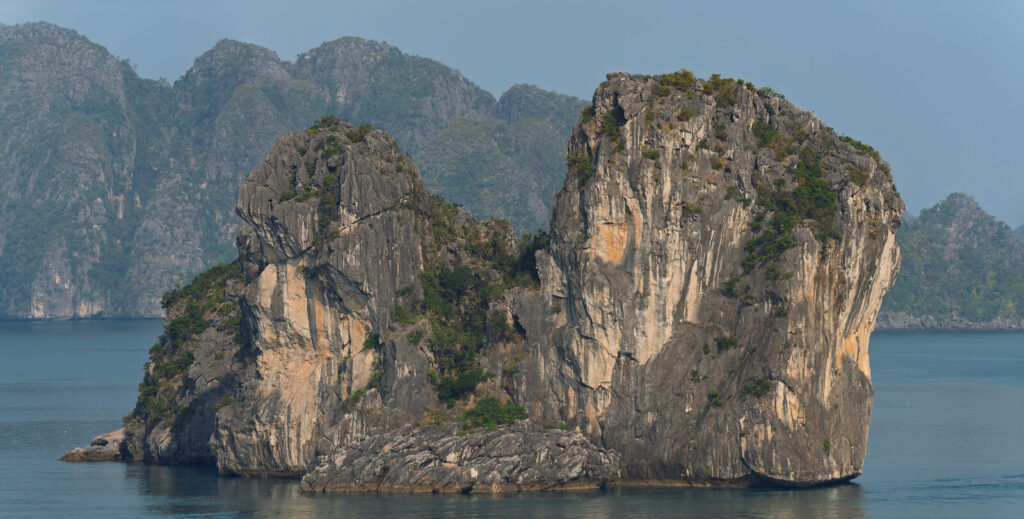 Limestone karst islands rising from the calm green water of Ha Long Bay, northern Vietnam