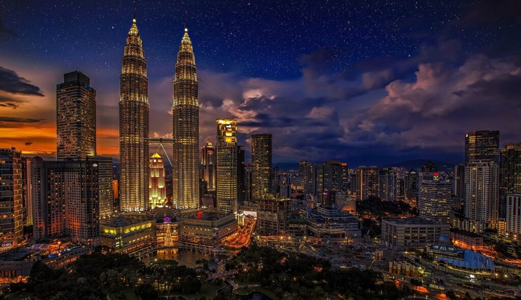 Kuala Lumpur skyline at dusk with the Petronas Towers — the destination for most KLIA airport transfers