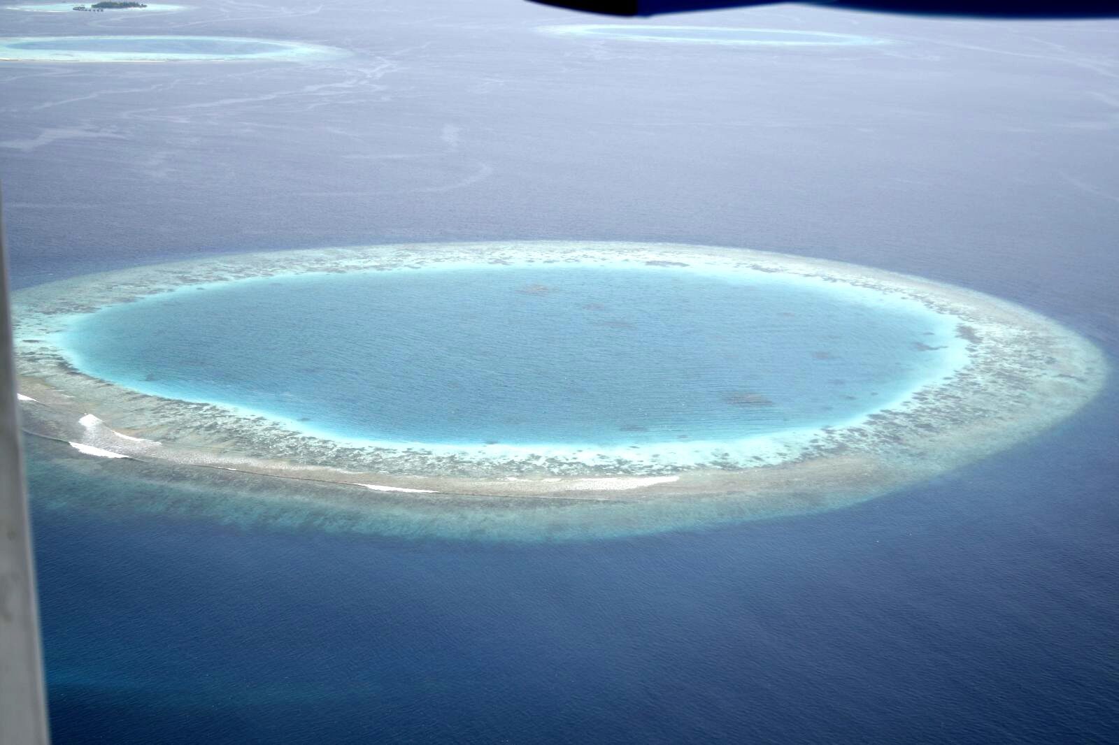 Aerial view of a Maldives coral atoll and lagoon from a seaplane window