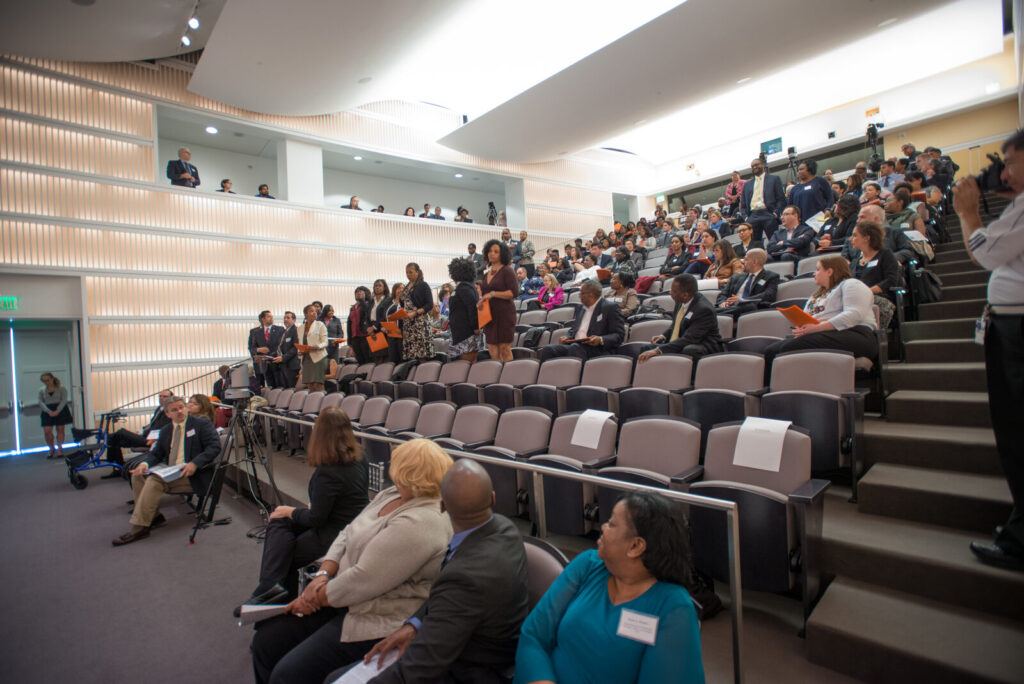 Delegates seated in an auditorium at a business conference