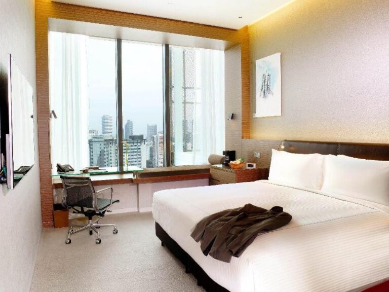 Guest room with work desk and Singapore skyline view at One Farrer Hotel