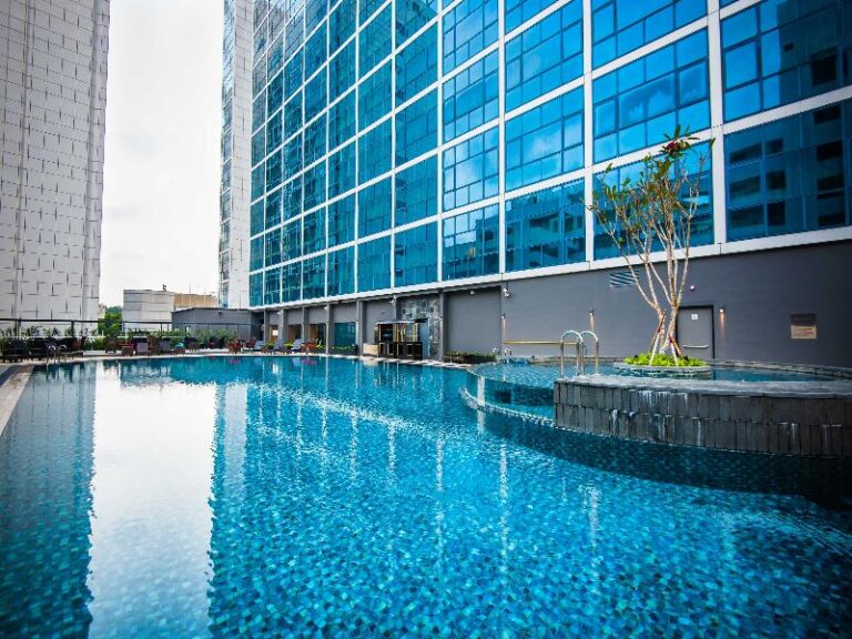 Outdoor swimming pool with city skyline at Orchard Hotel Singapore