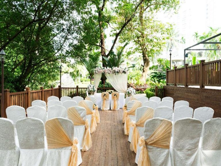 Outdoor garden ceremony set-up with rows of white chairs at Shangri-La Singapore
