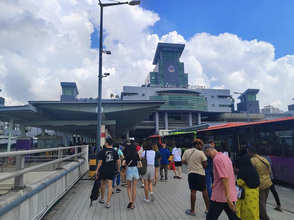 Travellers walking past coaches at Woodlands Checkpoint, the Singapore side of the Causeway to Johor Bahru